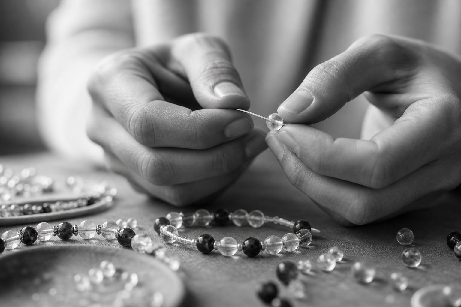Hands threading a crystal bead